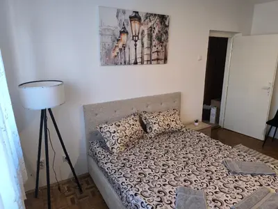 a bedroom with a bed and a lamp in it at R & P Apartman Mladenovac in Mladenovac
