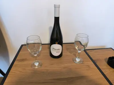 a bottle of wine and two wine glasses on a table at R & P Apartman Mladenovac in Mladenovac