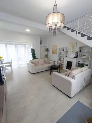 a living room with two white couches and a chandelier at House in Gardos in Zemun