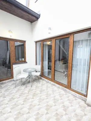 a patio with a table and chairs and windows at House in Gardos in Zemun