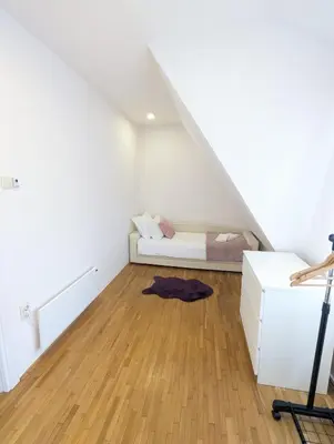 a white room with a bed in the attic at House in Gardos in Zemun