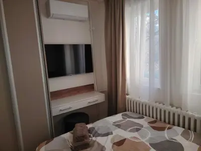 a bedroom with a bed and a mirror and a television at Stan na dan Bulevar in Belgrade