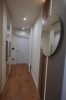 a hallway with a mirror and a white door at Stan na dan Bulevar in Belgrade