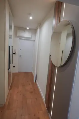 a hallway with a mirror and a white door at Stan na dan Bulevar in Belgrade