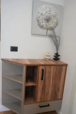 a wooden cabinet with shelves and a flower on the wall at Stan na dan Bulevar in Belgrade