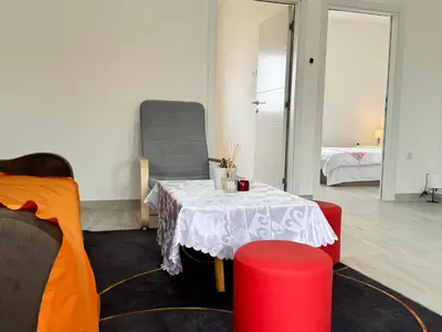a living room with a table and two chairs at Deluxe Belgrade Airport Single Room in Surčin
