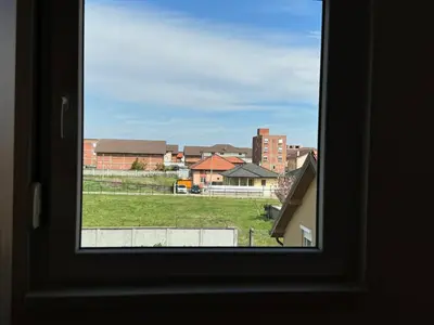 a window with a view of a field and buildings at Deluxe Belgrade Airport Single Room in Surčin