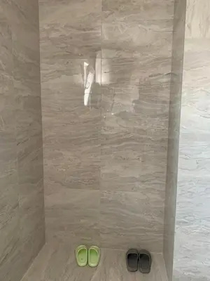 two pairs of green shoes on the floor of a shower at Deluxe Belgrade Airport Single Room in Surčin