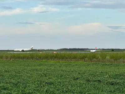 two planes on an airport runway with a green field at Deluxe Double Room Belgrade Airport in Surčin