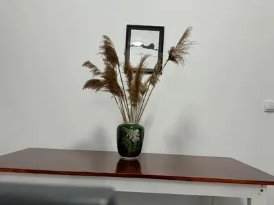 a green vase with a plant in it on a table at Deluxe Double Room Belgrade Airport in Surčin