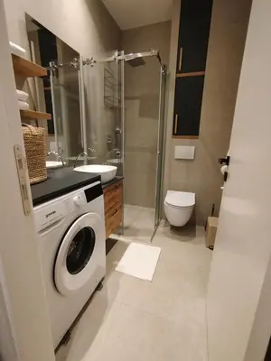 a bathroom with a washing machine and a toilet at Tiny Nest - Sava Center, Belgrade in Belgrade