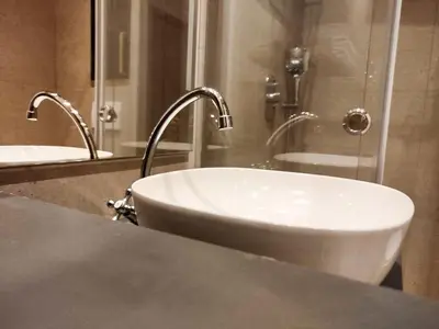 a bathroom with a sink and two faucets at Tiny Nest - Sava Center, Belgrade in Belgrade