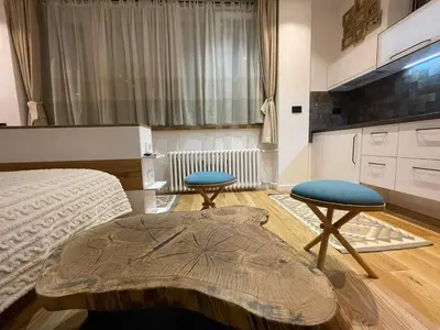 a bedroom with a bed and two stools in it at Tiny Nest - Sava Center, Belgrade in Belgrade
