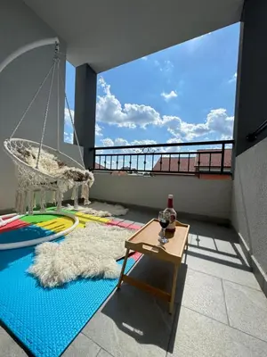 a room with a balcony with a swing and a table at Belgrade Airport luxury 2 room in Surčin
