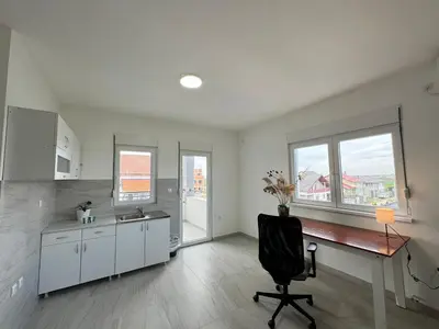 a kitchen with a desk and a chair in a room at Belgrade Airport luxury 2 room in Surčin