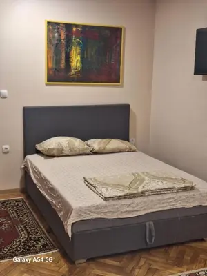 a bed in a bedroom with a painting on the wall at Dream 8 in Belgrade