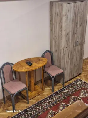 a wooden table with two chairs and a wooden door at Dream 8 in Belgrade