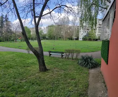 a park with a bench next to a tree at Aleksandar Residence in Belgrade