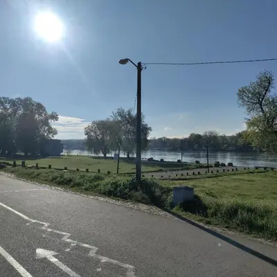 an empty road next to a field and a river at Aleksandar Residence in Belgrade