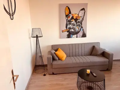 a living room with a couch and a painting of a dog at Your cozy place! in Belgrade