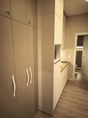 a kitchen with white cabinets and a wooden floor at Rossa & Bayo Apartments in Belgrade