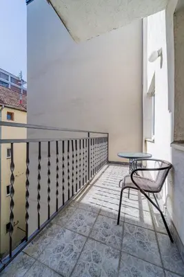 a balcony with a table and a chair at Apartman Igor 1 in Belgrade