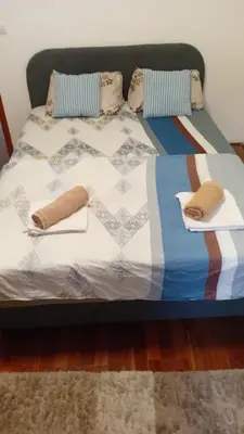 a bed with blankets and pillows on top of it at Apartman Igor 1 in Belgrade