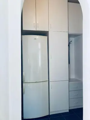 a kitchen with white cabinets and a refrigerator at Apartman Igor 2 in Belgrade