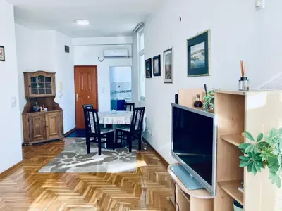 a living room with a television and a dining room at Apartman Igor 2 in Belgrade