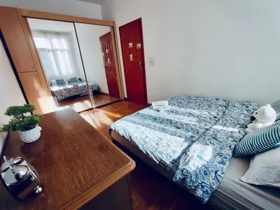 a bedroom with a bed and a table and a mirror at Apartman Igor 2 in Belgrade