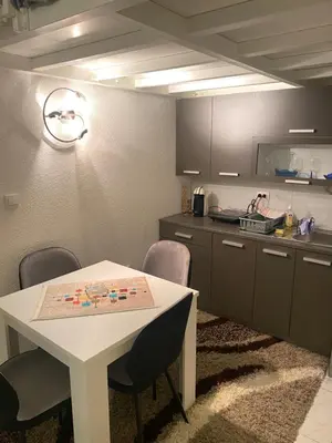 a kitchen with a table and chairs and a counter at Galerija apartman in Arandjelovac