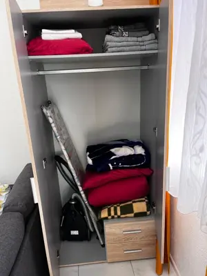 a walk in closet with red towels and a red bag at Galerija apartman in Arandjelovac