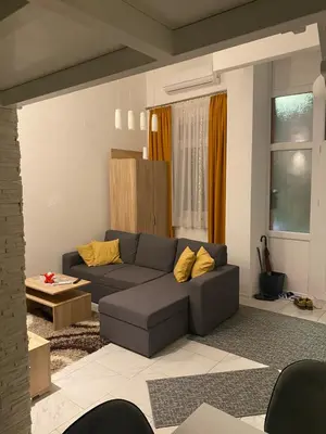 a living room with a gray couch and yellow pillows at Galerija apartman in Arandjelovac
