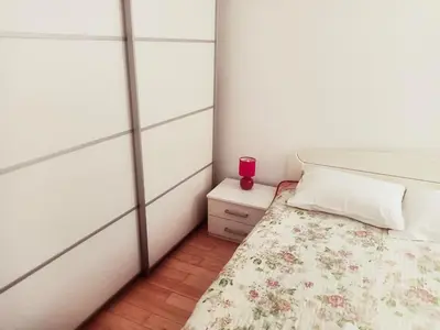 a small bedroom with a bed and a pink cup on a night stand at Marsala Family B&B in Belgrade