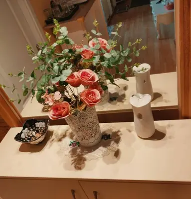 a table with two vases with roses in it at Marsala Family B&B in Belgrade