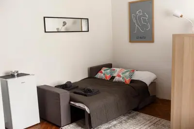 a small bedroom with a bed and a picture on the wall at Obilicev venac DM in Belgrade