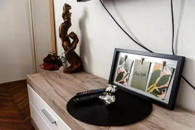a table with a picture frame and a remote control at Obilicev venac DM in Belgrade