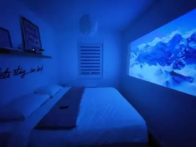 a bedroom with a bed and a large screen television at Apartment Endorfin - Modern apartment close to airport in Surčin