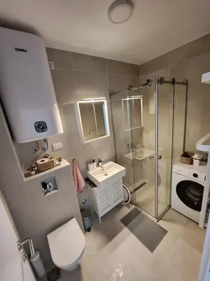 a bathroom with a shower and a toilet and a sink at Apartment Endorfin - Modern apartment close to airport in Surčin