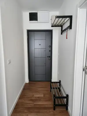 a hallway with a black door and a bench at Apartment Endorfin - Modern apartment close to airport in Surčin