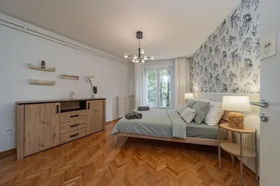 a bedroom with a bed and a dresser and a sink at Charming One Bedroom In The Heart of Belgrade in Belgrade