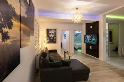 a living room with a couch and a chandelier at Oaza Apartmani Jakovo APOLON SPA in Jakovo
