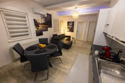 a living room with a table and a couch at Oaza Apartmani Jakovo APOLON SPA in Jakovo