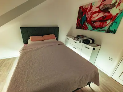a bedroom with a bed and a painting on the wall at Oaza Apartmani Jakovo APOLON SPA in Jakovo