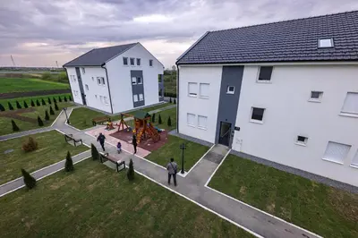 a group of people standing next to two white buildings at Oaza Apartmani Jakovo APOLON SPA in Jakovo