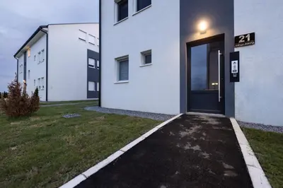a white building with a door on the side of it at Oaza apartmani Jakovo VENERA in Jakovo