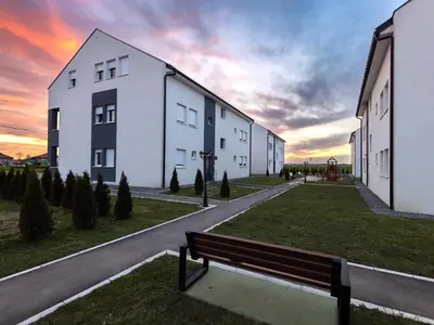 a bench sitting in the grass next to a building at Oaza apartmani Jakovo VENERA in Jakovo