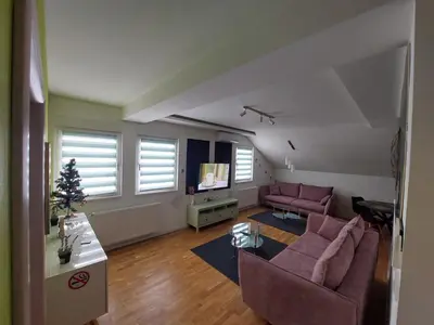 a living room with purple furniture and a christmas tree at Oaza apartmani Jakovo VENERA in Jakovo