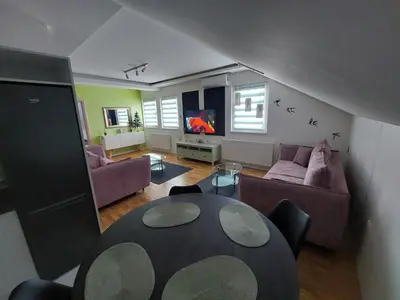 a living room with a table and a couch at Oaza apartmani Jakovo VENERA in Jakovo