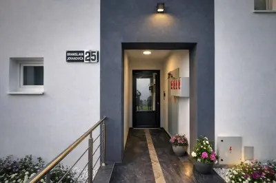a hallway of a building with a door and flowers at Oaza Apartmani Jakovo AFRODITA in Jakovo